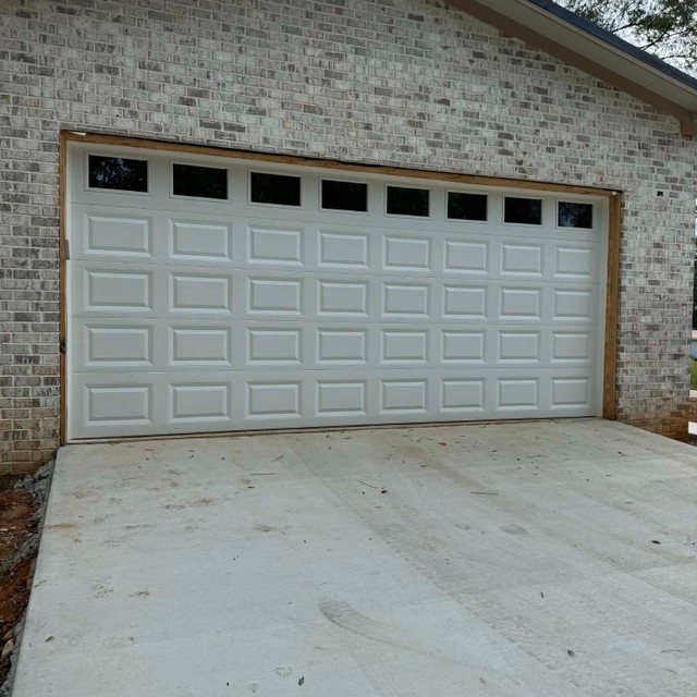 White garage door with windows on brick home